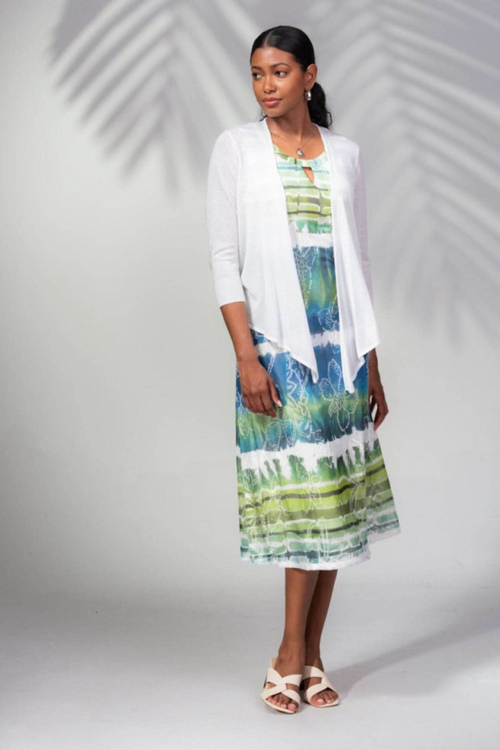 Femme portant une veste ouverte blanche sur une robe colorée, idéale pour une soirée estivale ou la mi-saison.