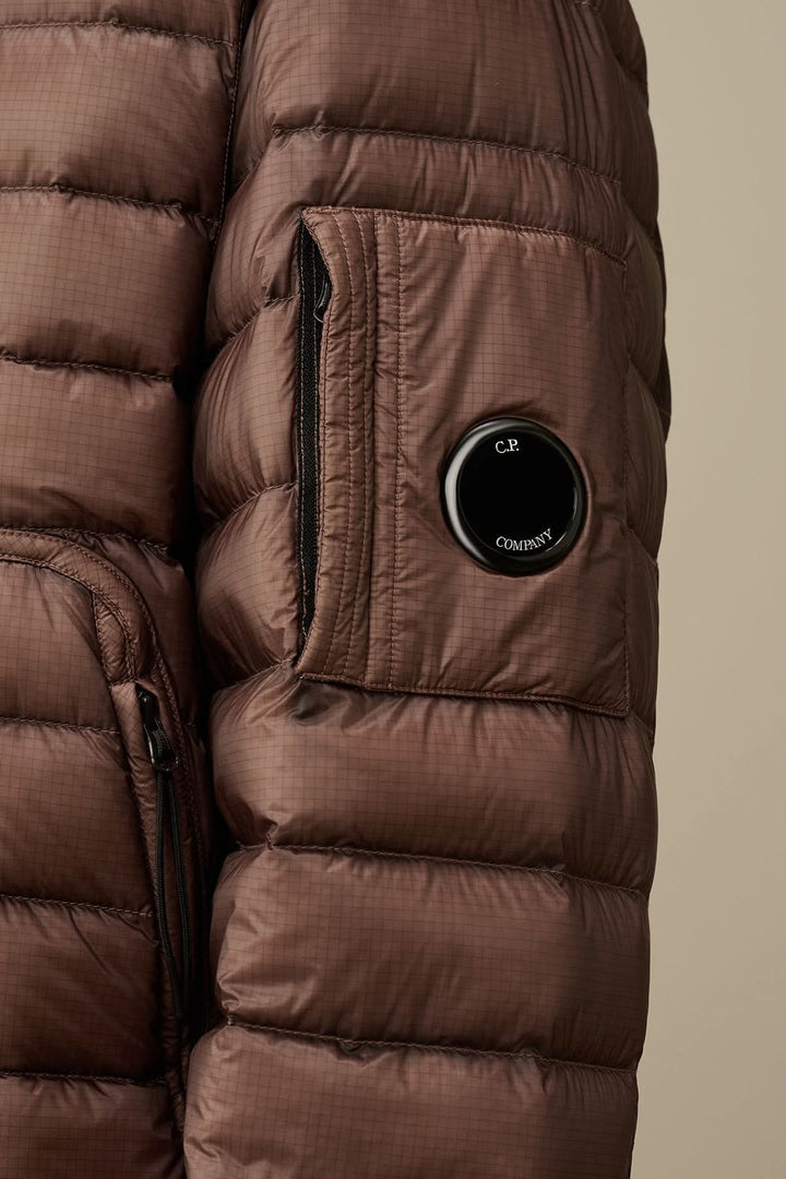 Zoom sur une doudoune brune avec poche zippée et détail de lentille, en tissu léger D.D. Shell.