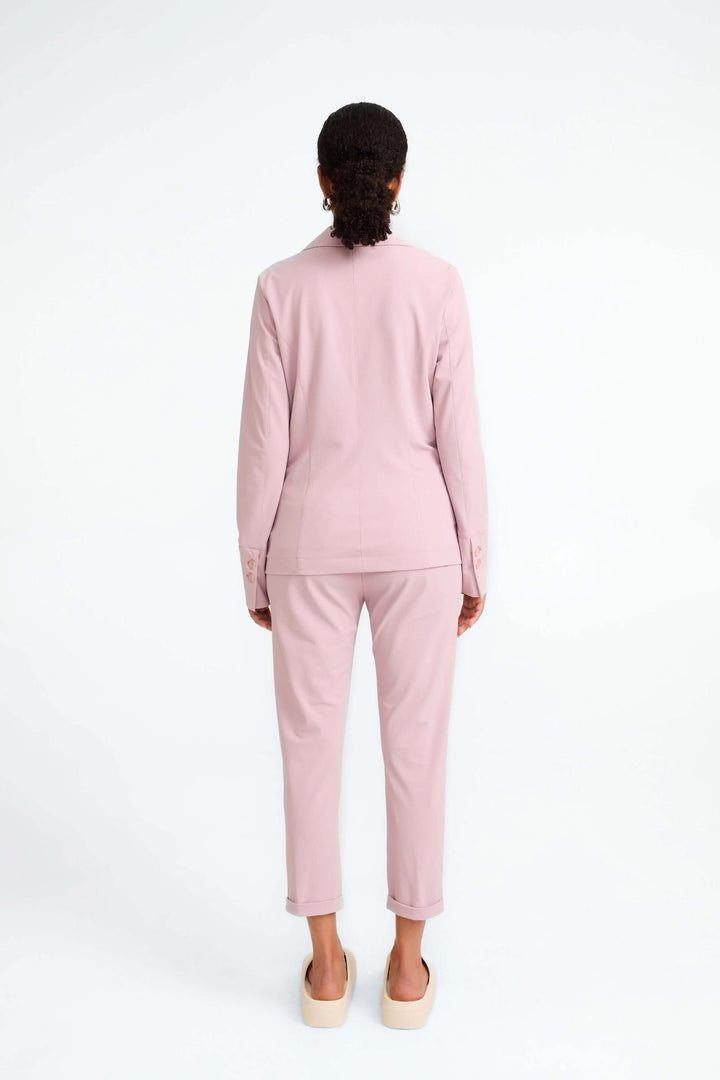 Vue arrière d'un veston structuré rose, associé à un pantalon coordonné, offrant confort et élégance.