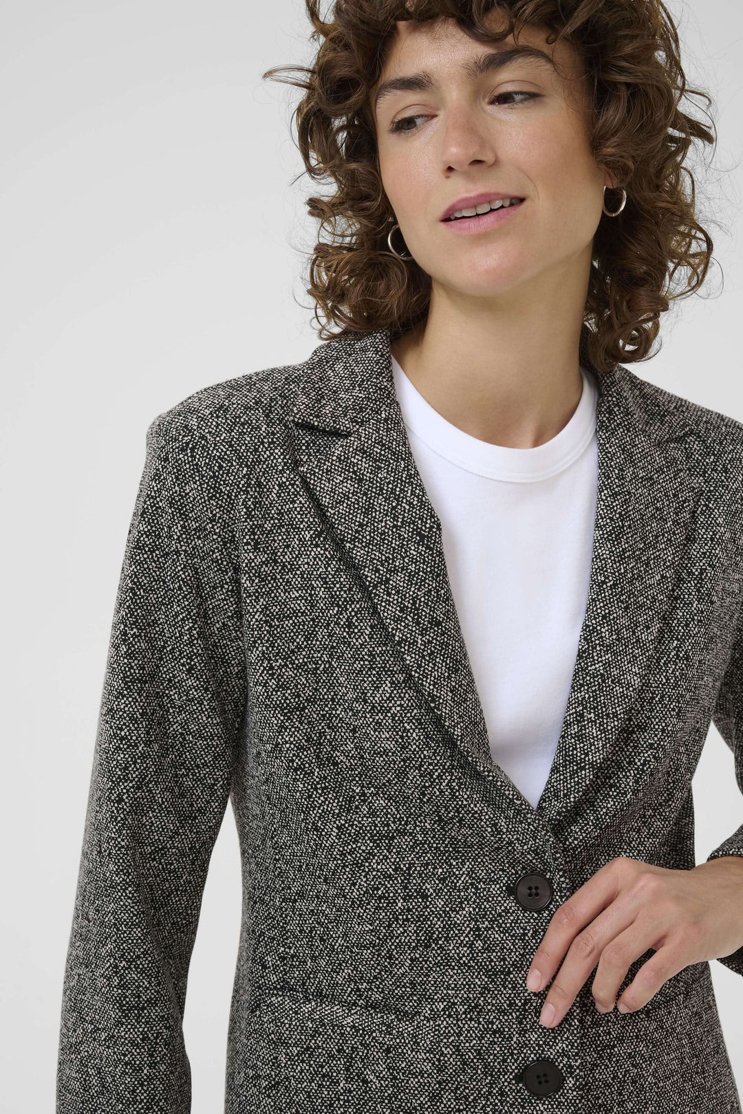 Veston Vineke en tissu texturé avec une coupe structurée et fermeture à un bouton, porté par une femme.