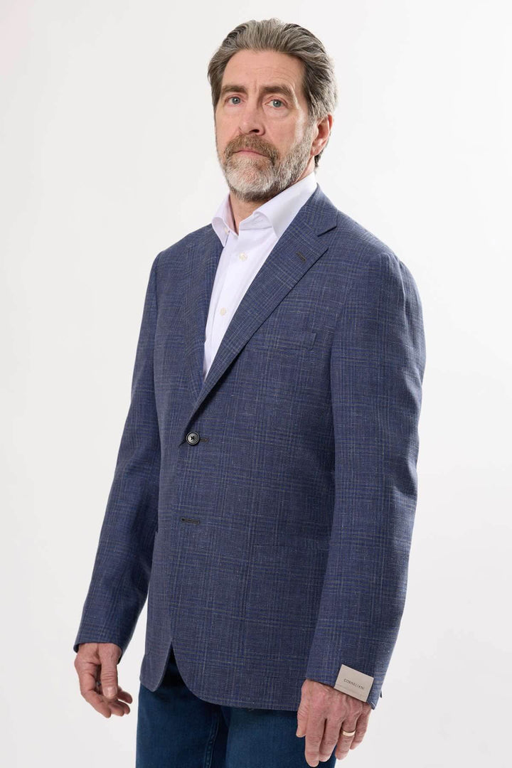 Homme en veston à carreaux discrets, coupe semi-ajustée, idéal pour événements formels et professionnels.