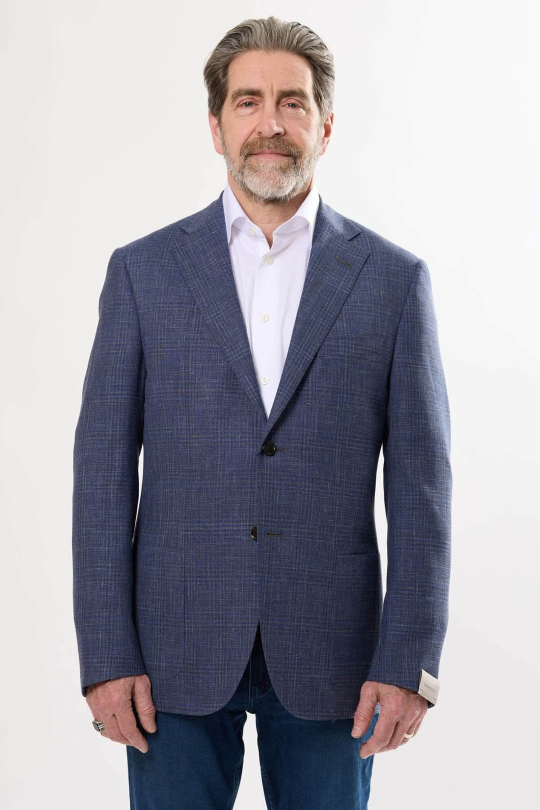 Homme portant un veston à carreaux discrets, style moderne et élégant, adapté pour diverses occasions.