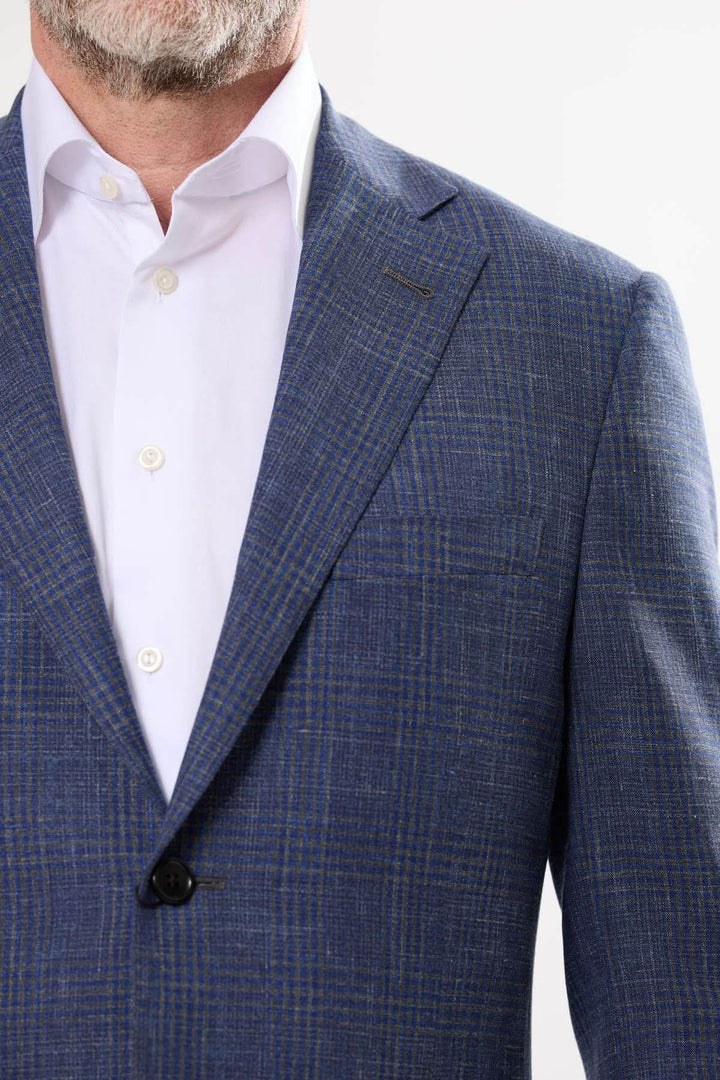 Veston à carreaux discrets, léger et moderne, avec fermeture à deux boutons et revers à cran classique.