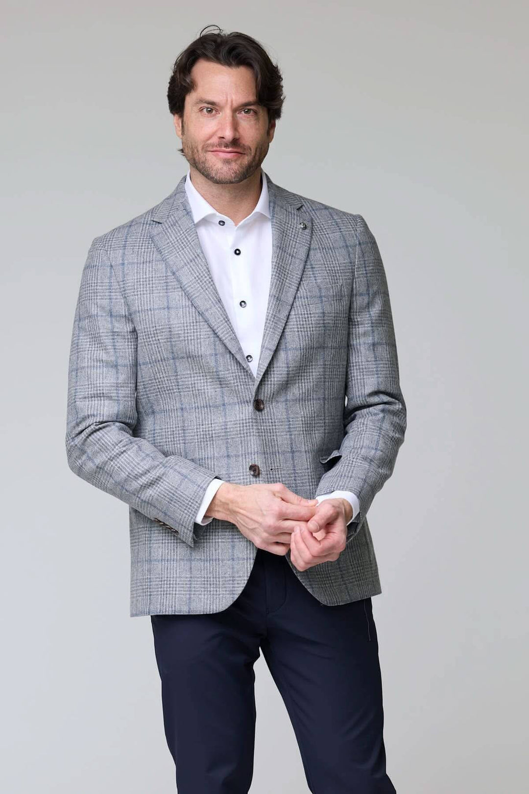 Homme portant un veston à carreaux moderne élégant, coupe ajustée, parfait pour bureau et occasions spéciales.