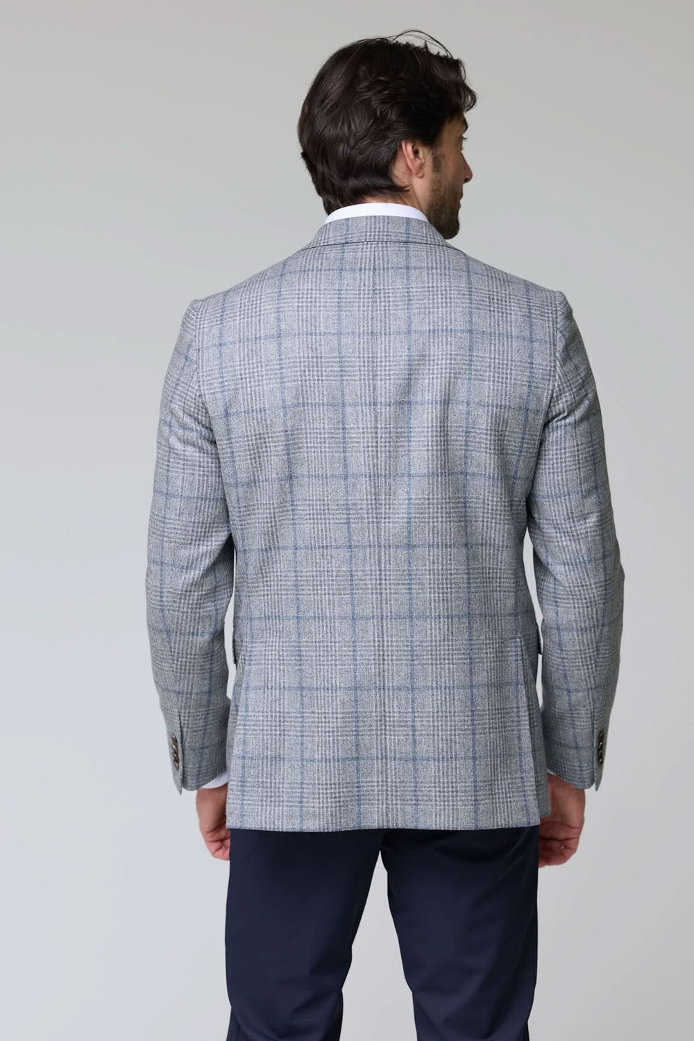 Veston à carreaux moderne pour homme, vue arrière montrant la coupe ajustée et le tissu à motif carreaux, parfait pour le bureau.
