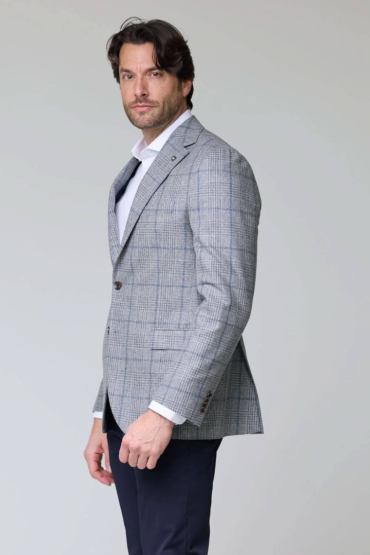 Homme portant un veston à carreaux moderne, coupe ajustée, idéal pour les occasions spéciales et le bureau. Tissu à motif carreaux.