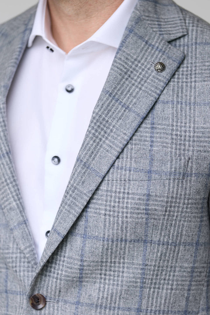 Homme portant un veston à carreaux moderne, coupe ajustée, élégant pour bureau et occasions spéciales.