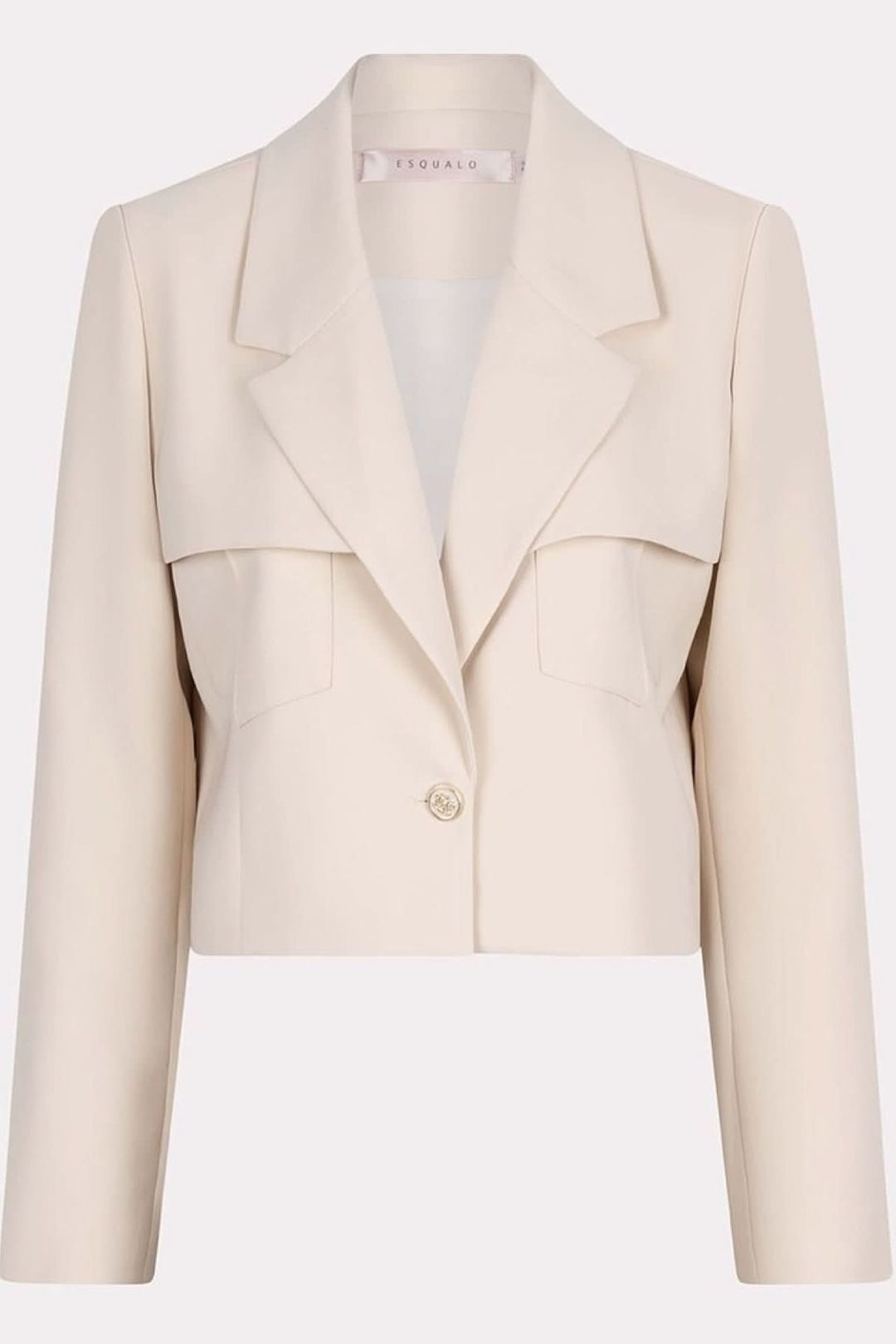 Veston court structuré beige avec poches surdimensionnées et bouton doré, style moderne et féminin.
