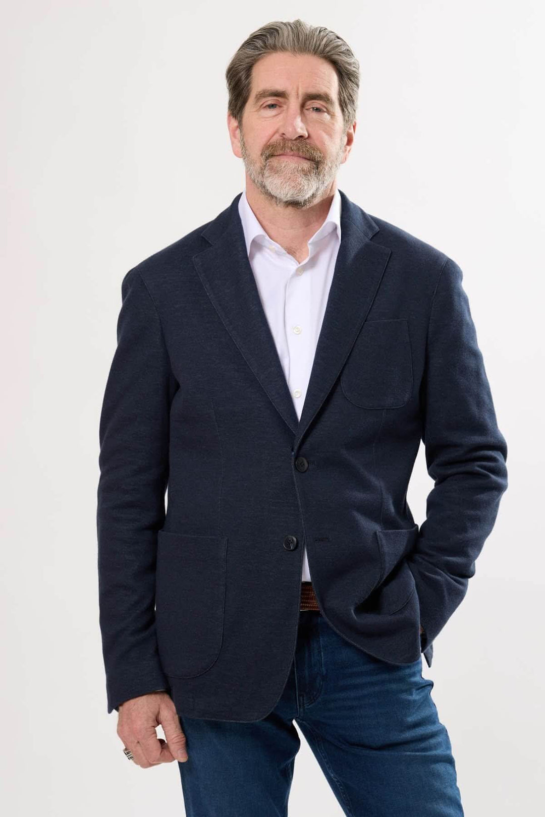 Homme portant un veston décontracté élégant, coupe souple, avec poches plaquées, style moderne et confortable.