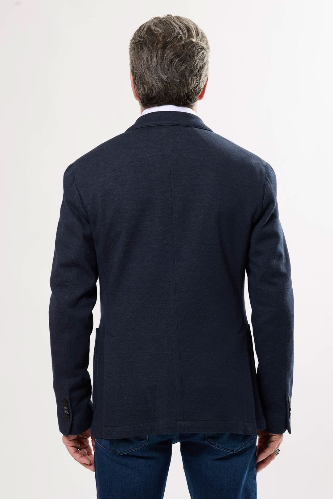 Homme portant un veston décontracté bleu marine, vue de dos, avec coupe moderne et tissu extensible.