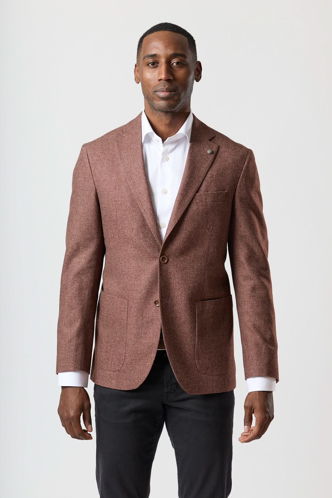 Homme portant un veston déstructuré en flanelle deux boutons à revers crantés, sur chemise blanche.