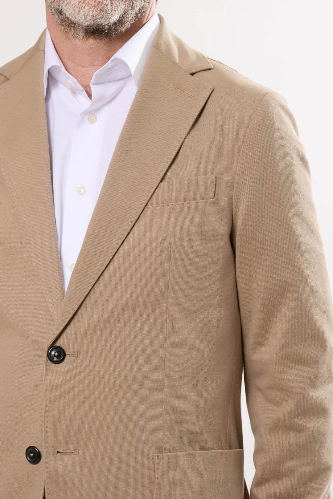 Veston en coton extensible beige avec fermeture à deux boutons et poche plaquée, idéal pour tenues habillées ou décontractées.