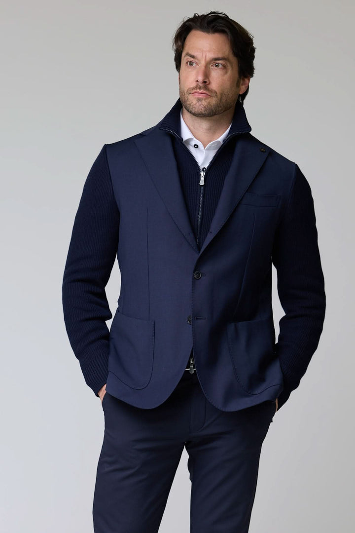 Homme portant un veston hybride tricot et tissu bleu avec col à revers classique.