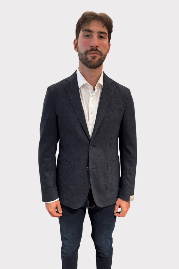 Homme portant un veston gris moderne en laine-cachemire avec une coupe ajustée.