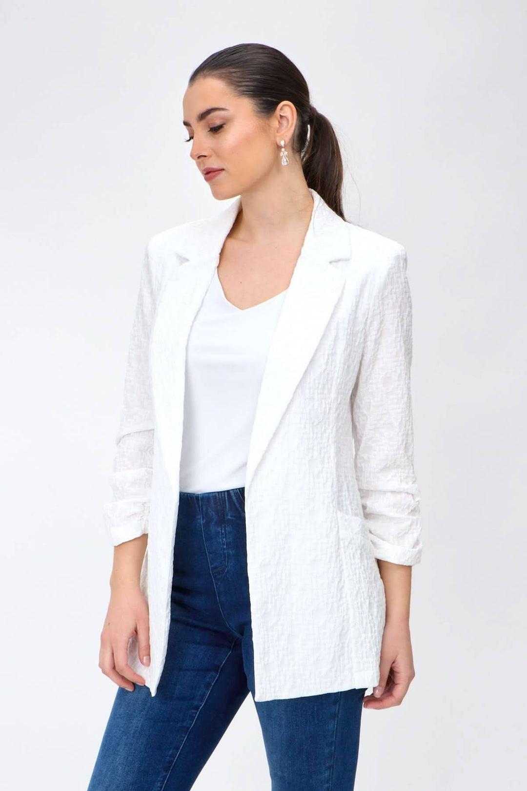 Veston léger blanc avec manches froncées, idéal pour un style décontracté et élégant, porté avec un haut et un jeans.