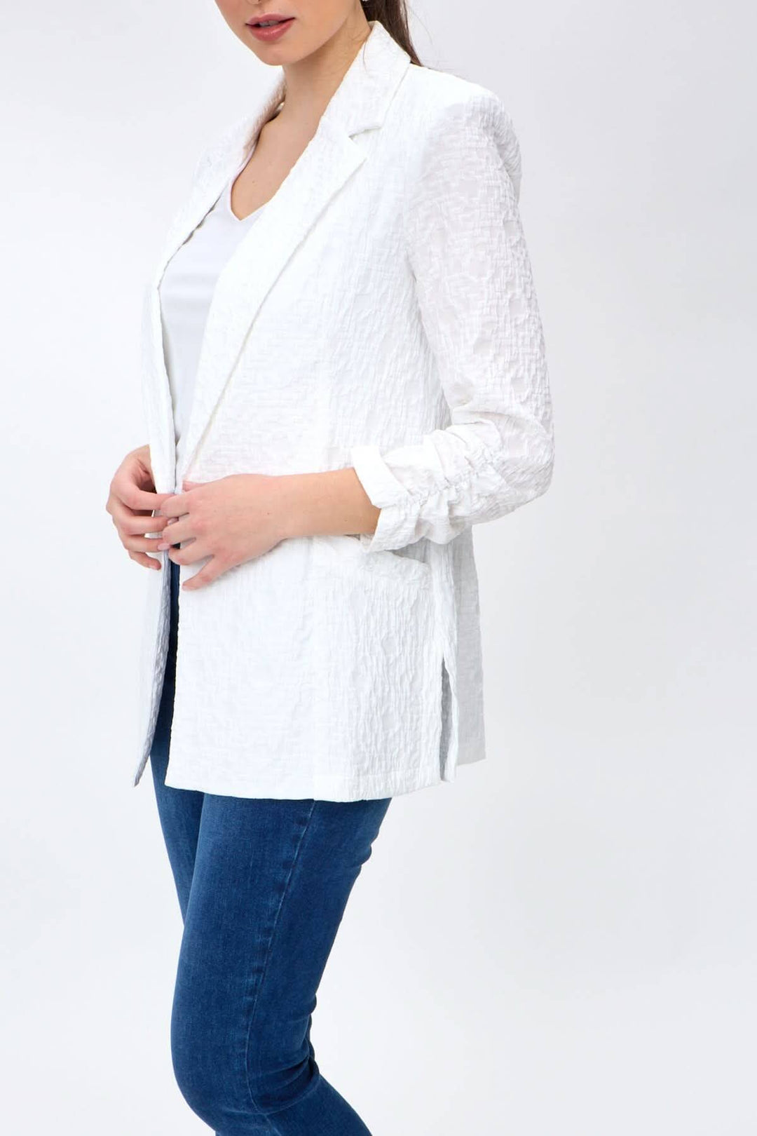 Veston léger souple blanc avec manches froncées, porté avec un t-shirt, pour un style décontracté et élégant.