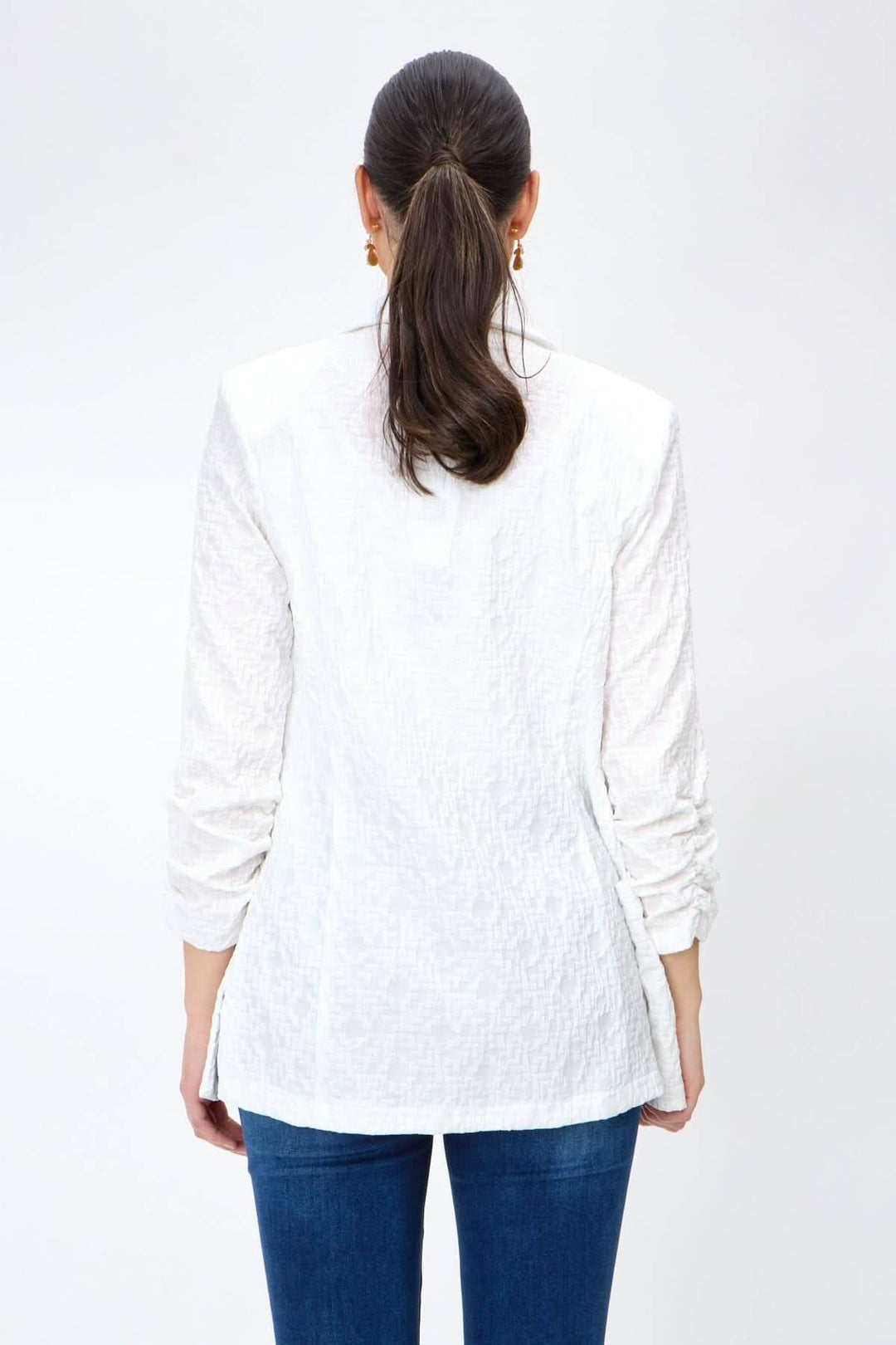 Veston léger blanc, souple, ouvert avec manches longues, finition soyeuse, style décontracté, pris de dos.