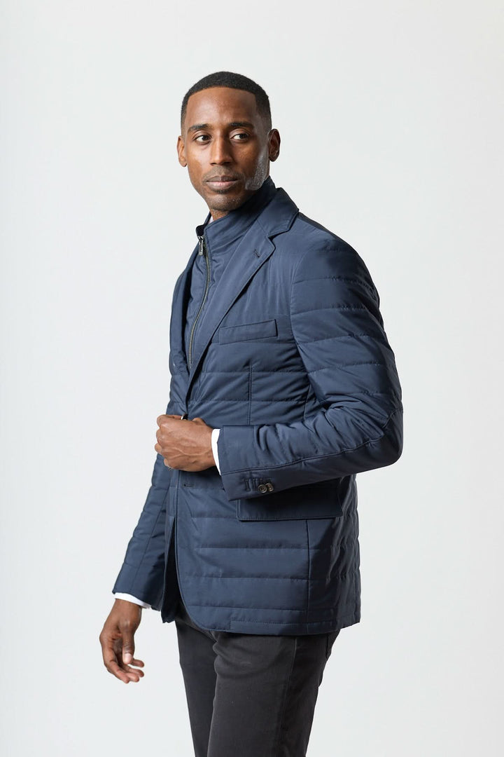 Homme portant un veston matelassé à encolure amovible élégant et moderne signé Corneliani, style polyvalent et haut de gamme.