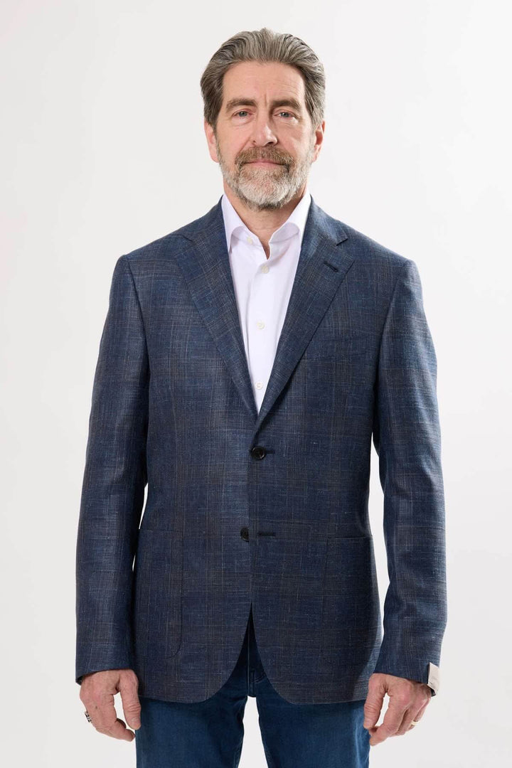 Homme portant un veston à motif discret, élégant et semi-ajusté, idéal pour le bureau ou les événements habillés.
