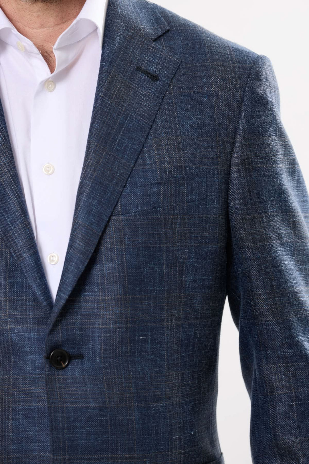 Veston à motif discret en tissu chiné, élégant et sophistiqué pour homme moderne, porté sur une chemise blanche.