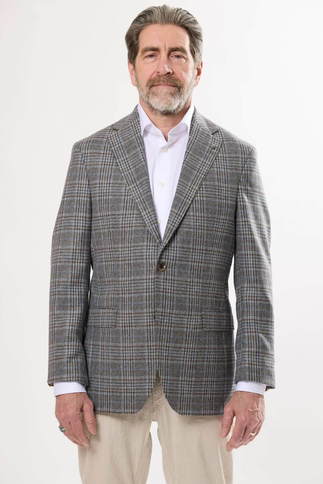 Homme portant un veston prince-de-galles, style élégant et contemporain, idéal pour les occasions habillées.