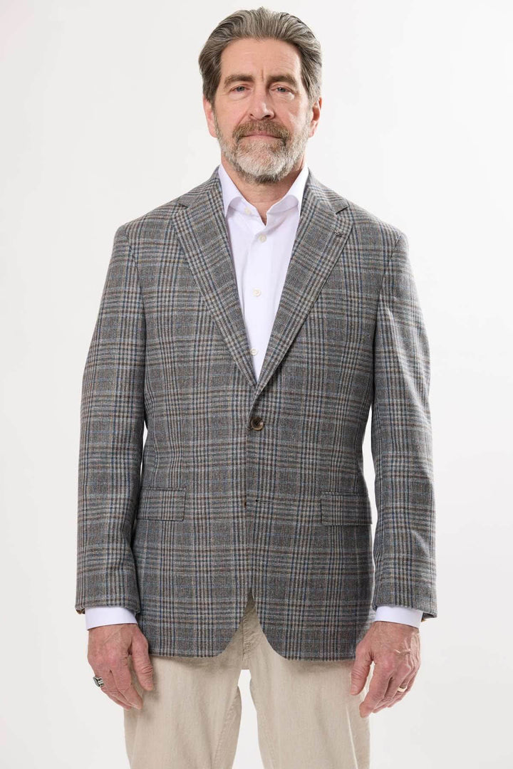 Homme portant un veston prince-de-galles, style élégant et contemporain, idéal pour les occasions habillées.