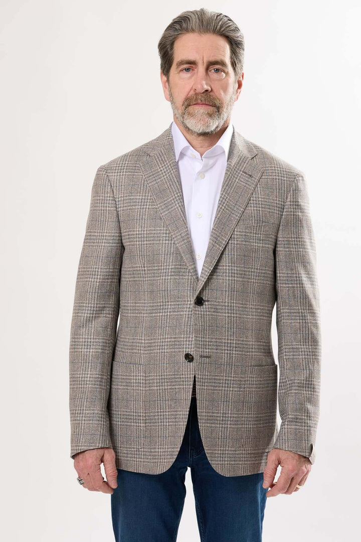 Veston à motif prince-de-galles, élégant et contemporain, porté avec une chemise blanche et un pantalon en jean.