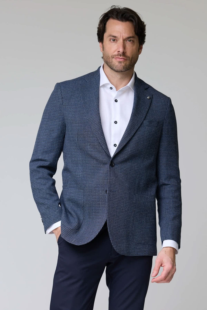 Homme portant un veston à motif texturé avec col à revers classique et poche poitrine.