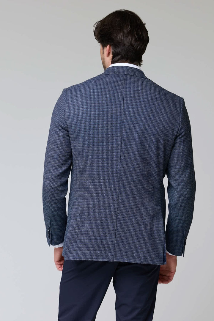 Homme portant un veston à motif texturé vu de dos avec fermeture à deux boutons et col à revers classique.