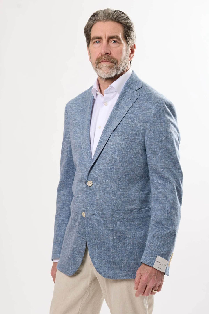 Homme portant un veston texturé bleu, élégant et léger, idéal pour les journées d'été ou les événements habillés.