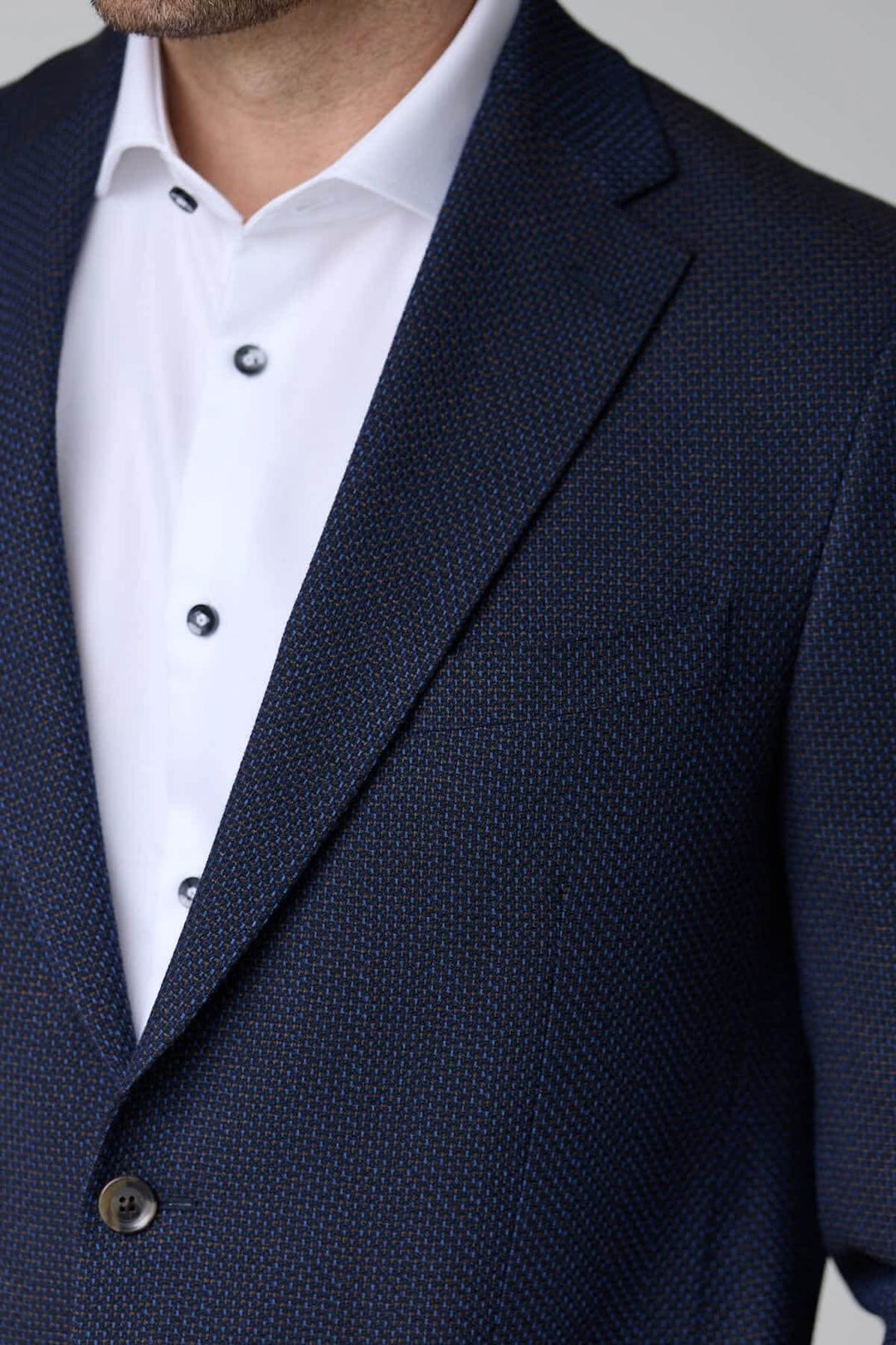 Veston texturé à coupe moderne élégant avec maille souple, idéal pour le bureau et sorties habillées, porté avec une chemise blanche.