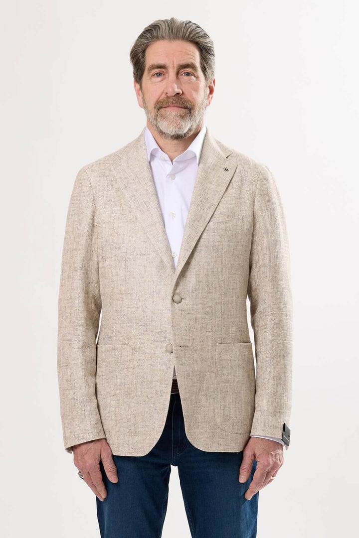 Homme portant un veston texturé d'été beige avec une chemise blanche, style décontracté chic.
