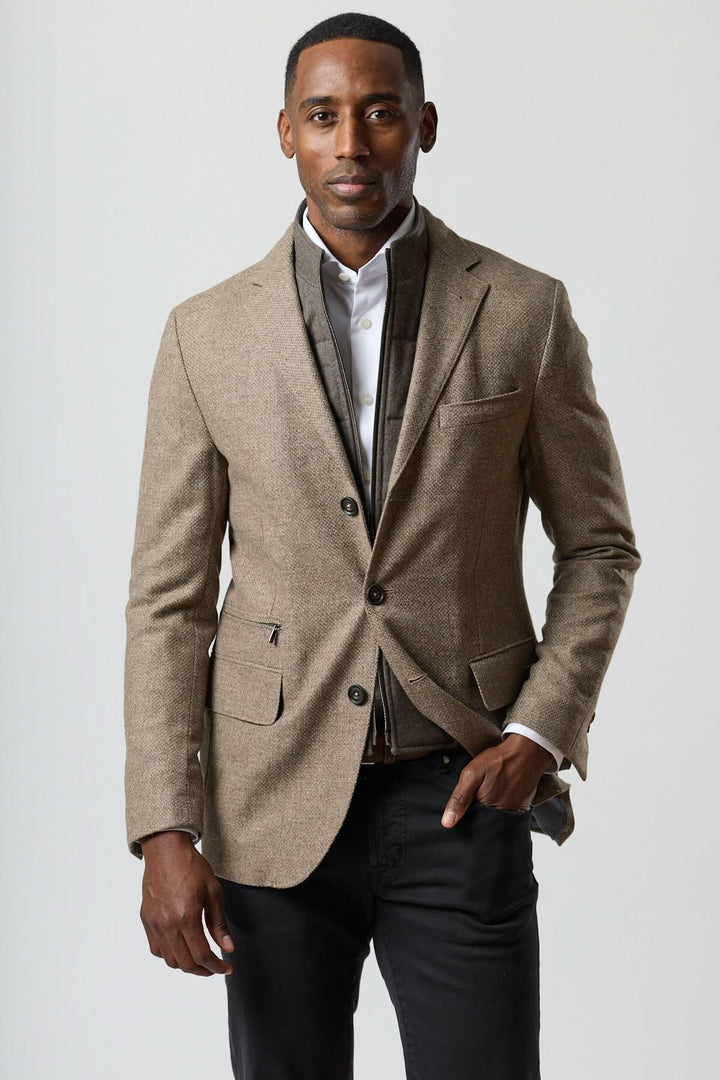 Homme portant un veston texturé en laine avec col amovible intégré, tons beige doré, côté contemporain et élégant.