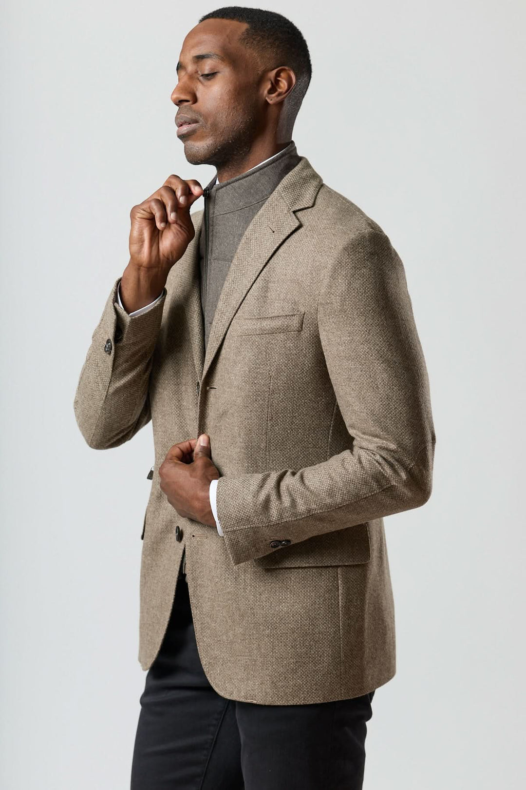 Veston texturé en laine avec col amovible intégré en beige doré, porté par un homme, élégant et moderne.