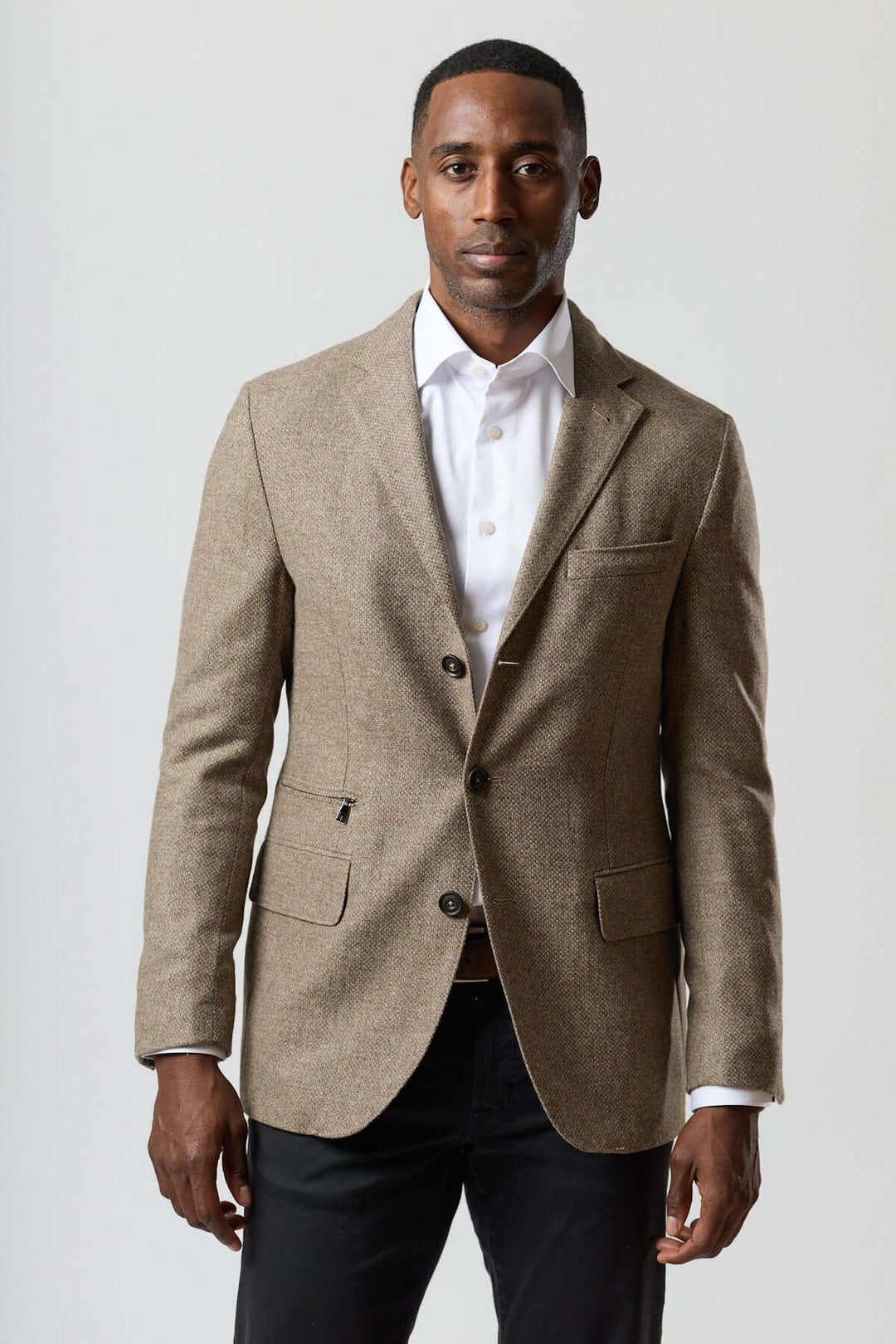 Homme portant un veston texturé en laine avec col amovible intégré, tons beige doré, insert zippé ton sur ton. Élégance moderne Corneliani.