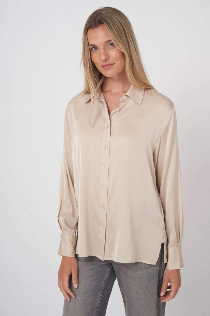 Chemise en soie fluide beige, élégante avec texture satinée, idéale pour un look raffiné et confortable.