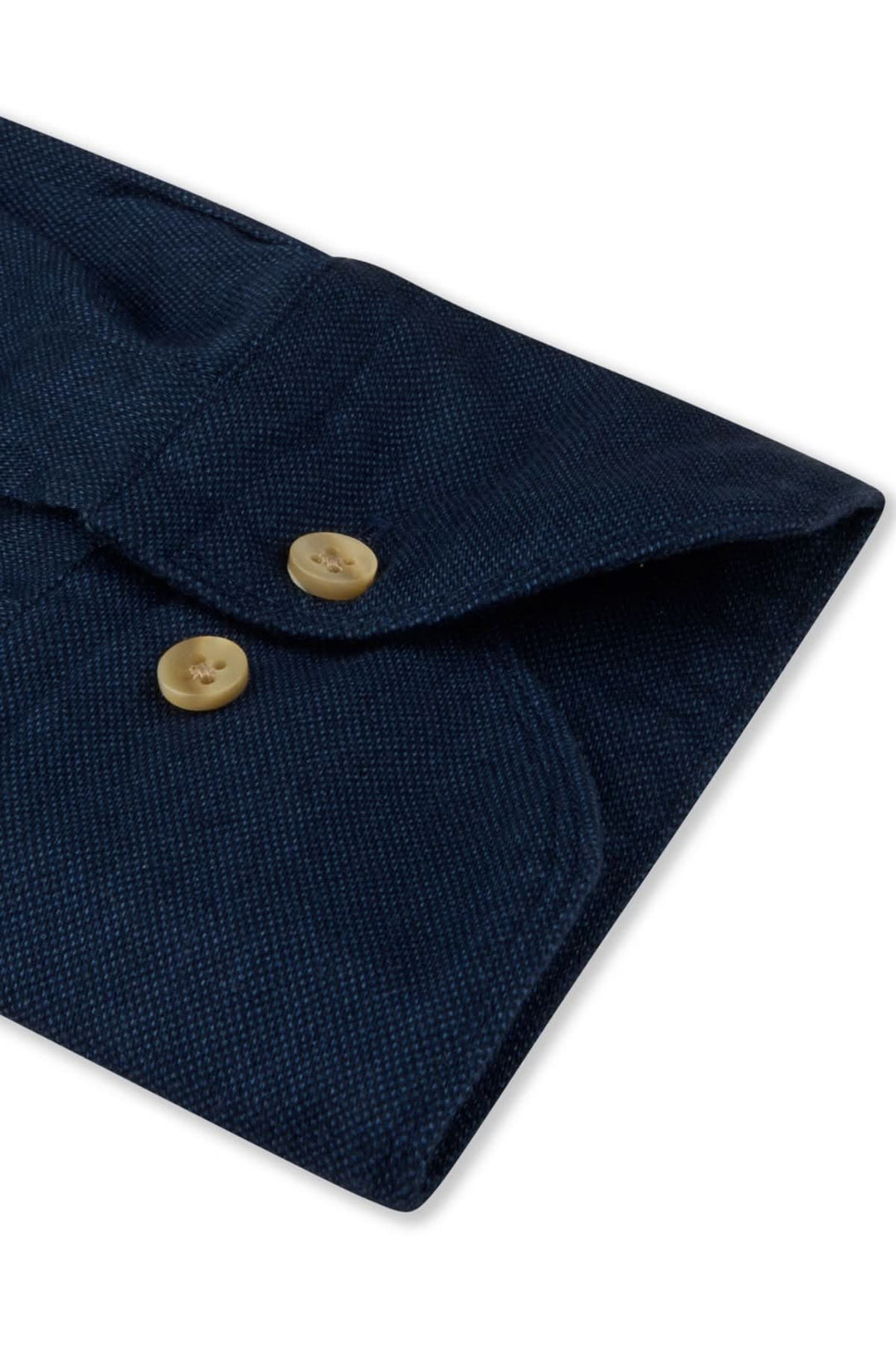 Détail d'une chemise sport en coton, col semi-italien et boutons dorés sur tissu bleu foncé.