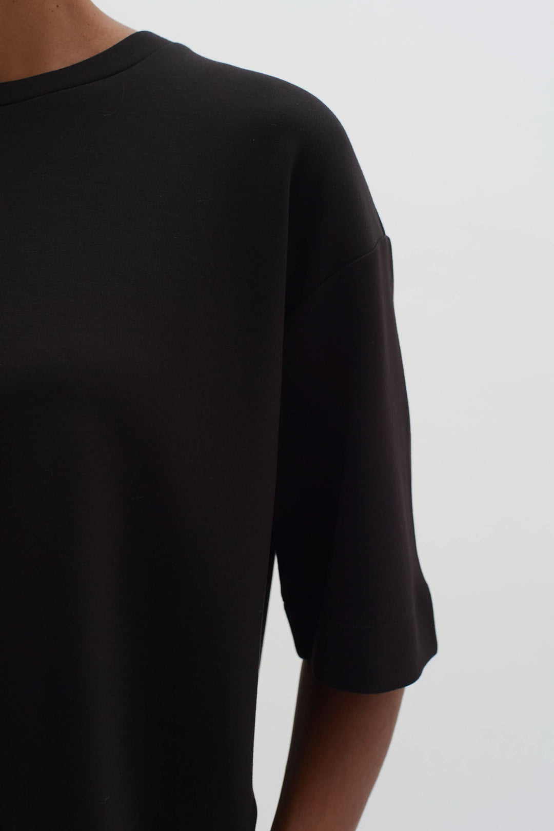 T-shirt ample Pannie en noir avec manches 1/2 et encolure ronde, confort et style.