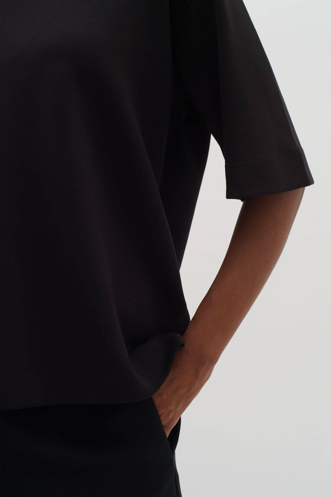 T-shirt Pannie ample noir avec manches 1/2 et encolure ronde, stylé et confortable.