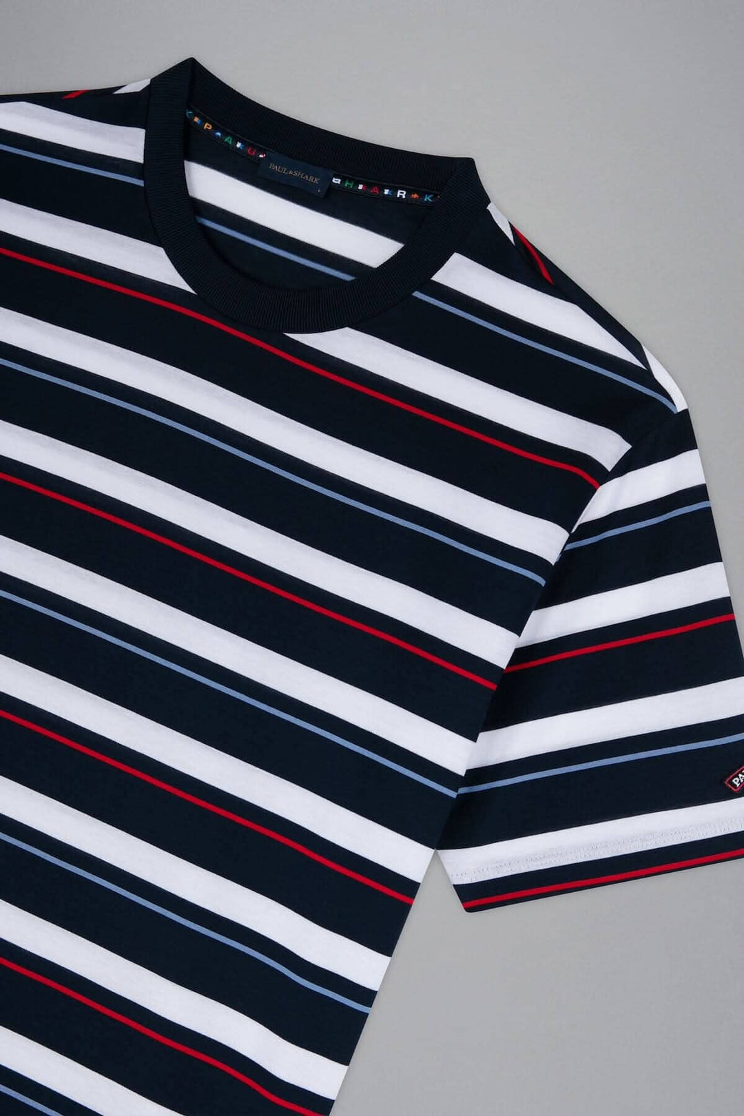 T-shirt ligné multicolore Paul and Shark avec des rayures bleues, rouges et blanches sur fond marine.