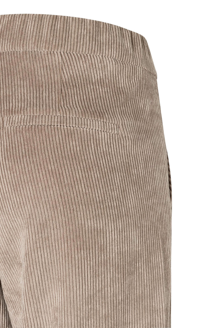 Détail de pantalons en velours côtelé beige, mettant en avant la texture et la taille élastique sans fermeture.