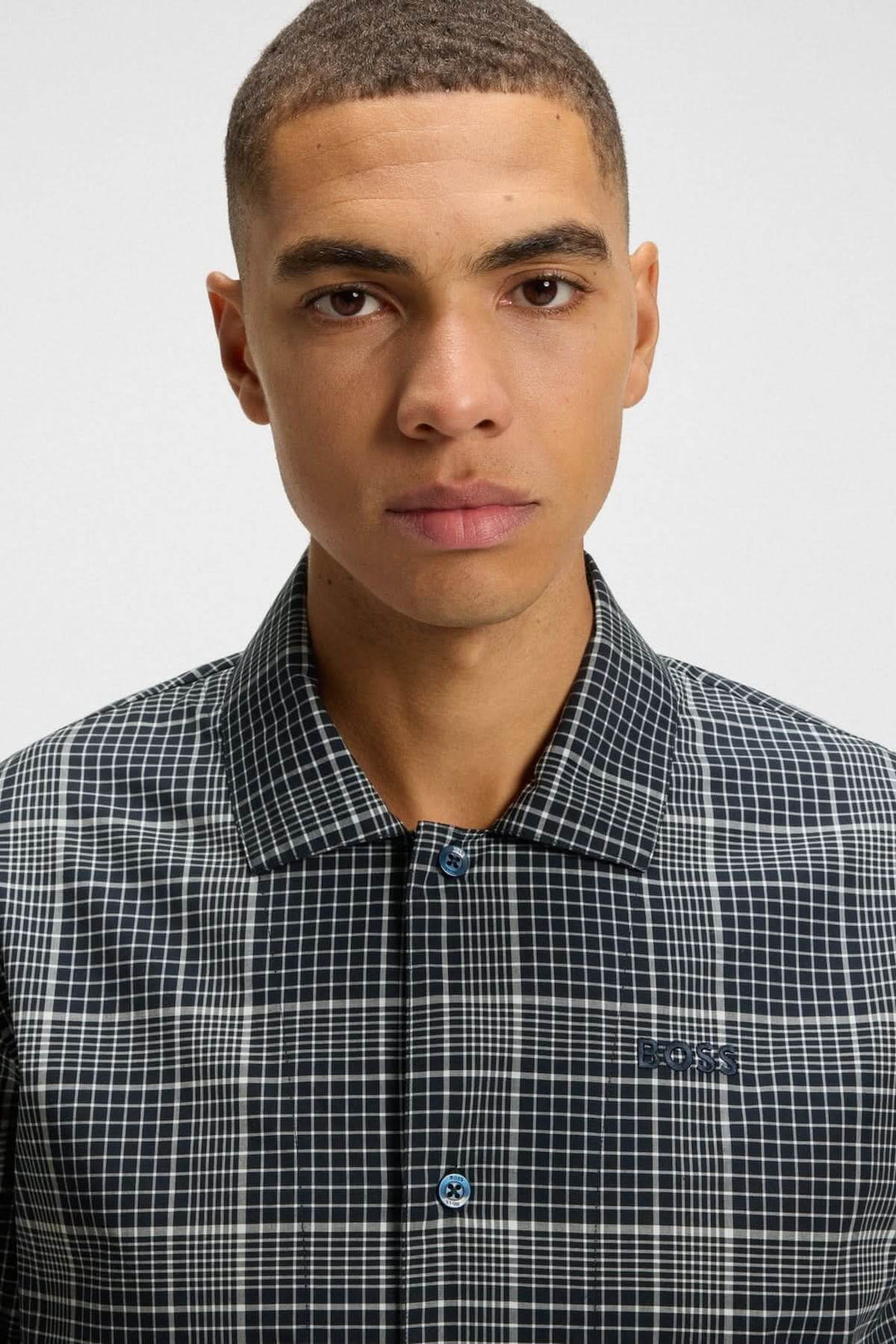 Homme portant le Pyjama à carreaux en coton et lyocell BOSS présenté en vue frontale, montrant le motif classique et le col élégant.