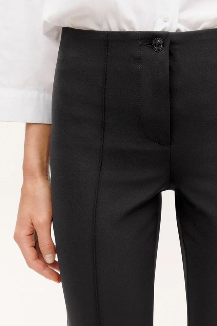 Pantalon slim Ros de Cambio, détail de la taille avec fermeture éclair et bouton, tissu techno