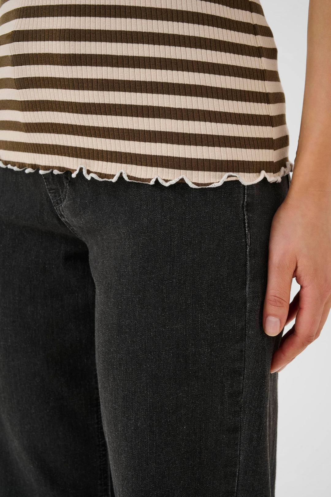 Camisole ribba à rayures horizontales avec finitions ondulées, portée avec un jean noir.