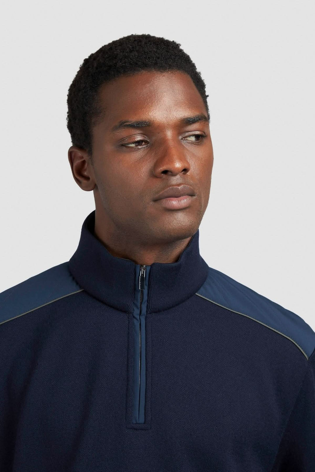 Homme portant un chandail en tricot à col zippé et empiècements contrastants, style décontracté