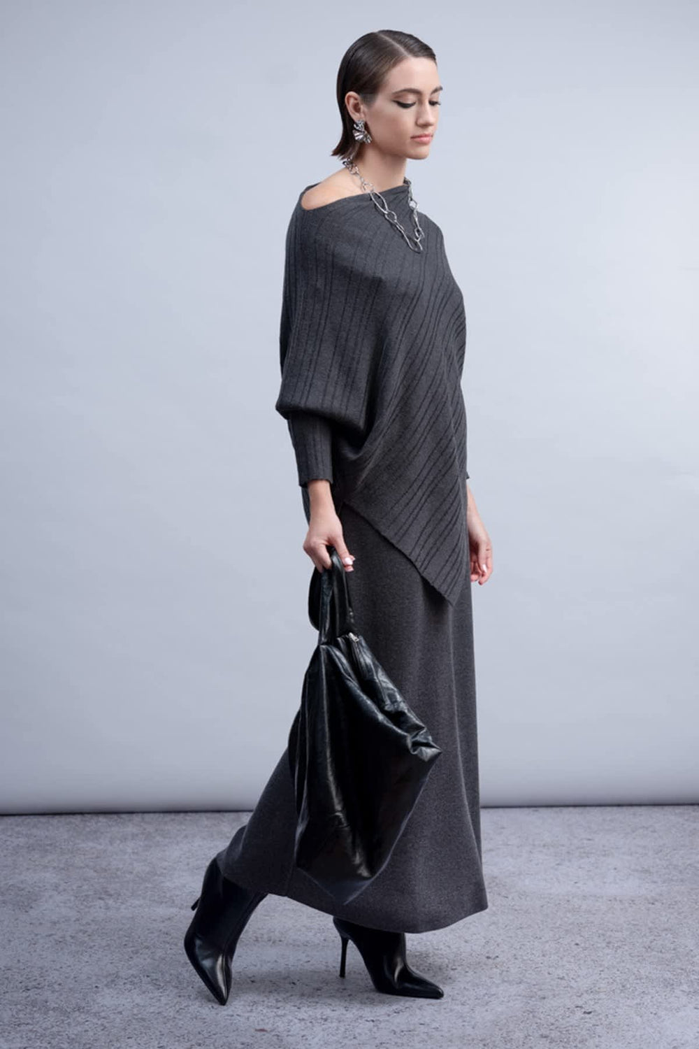 Front view of the Haako women's black asymmetrical sweater with cut-out shoulders - Valérie Simon