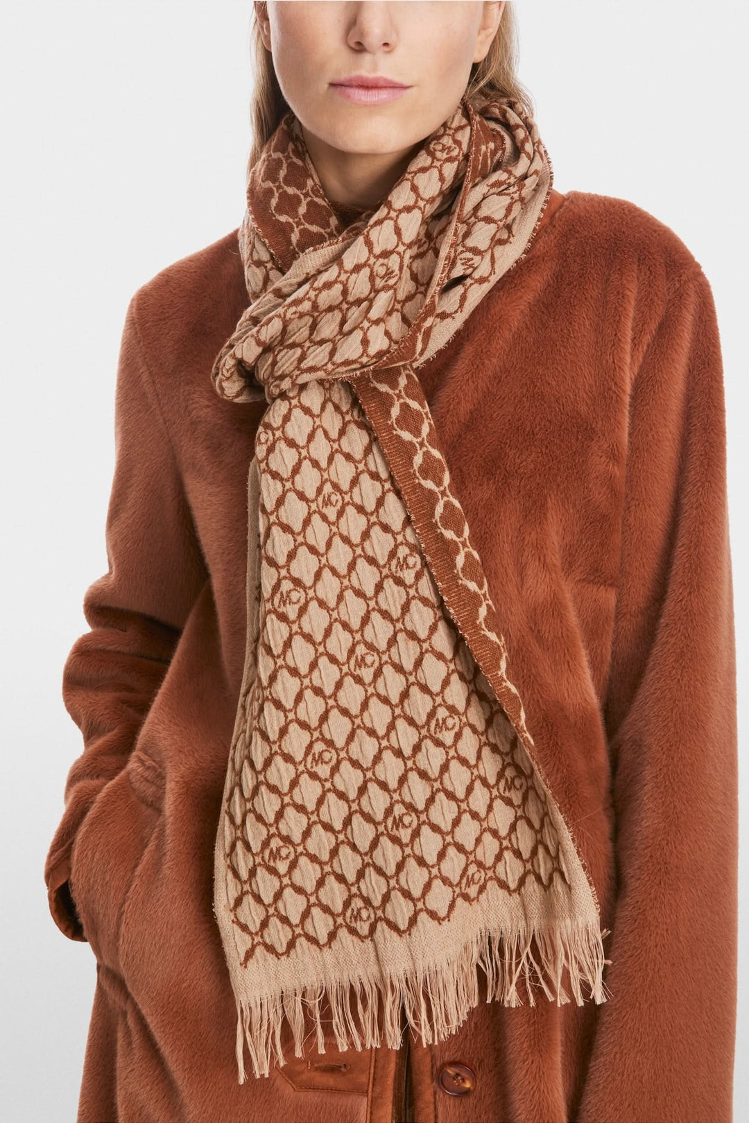 Écharpe en laine bicolore avec franges, portée sur un manteau marron, idéale pour les journées froides.