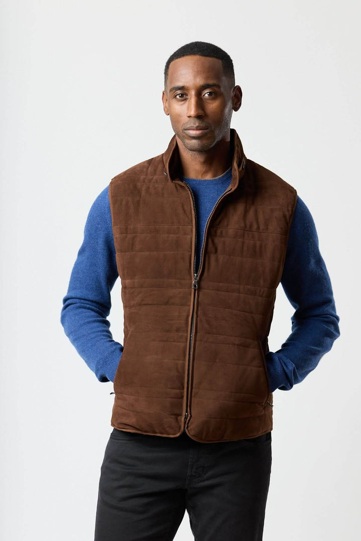 Homme portant une élégante Veste sans manches en simili suède marron, associée à un pull bleu, mettant en valeur une allure raffinée et contemporaine.