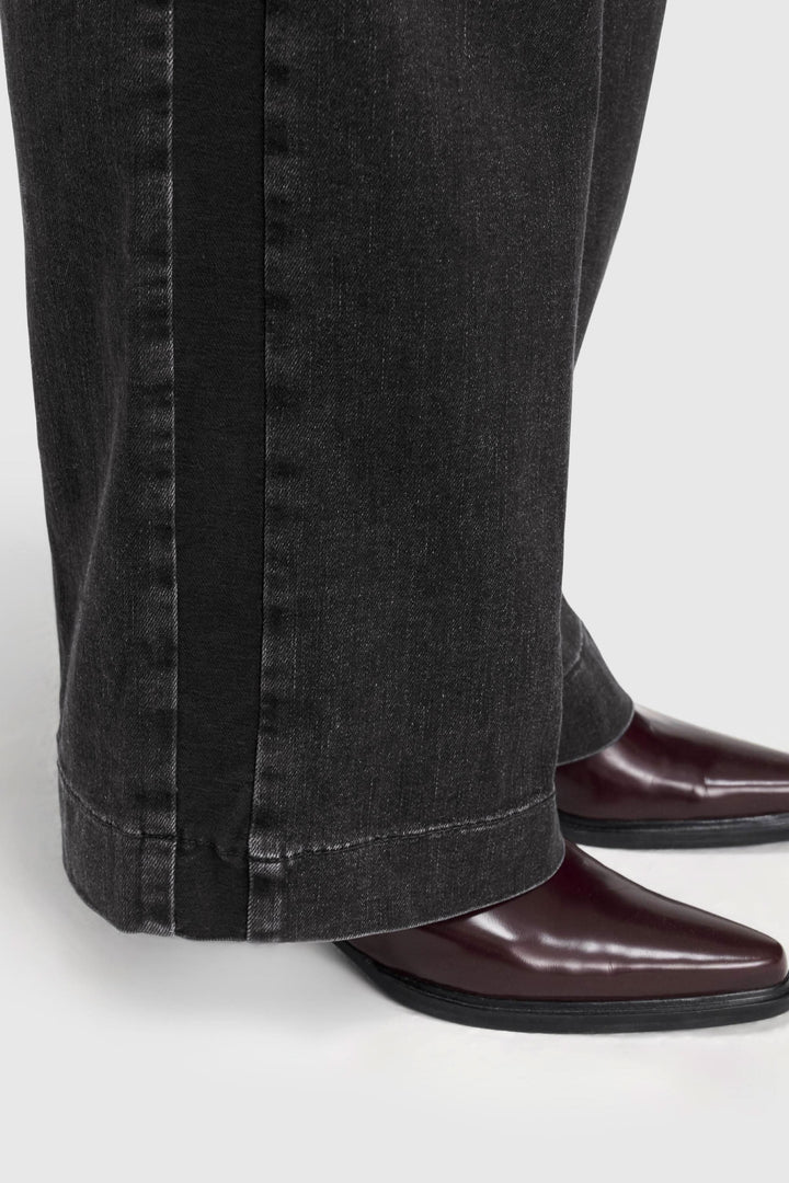 Jean à jambe large au fini délavé associé à des chaussures élégantes, pour un look tendance.