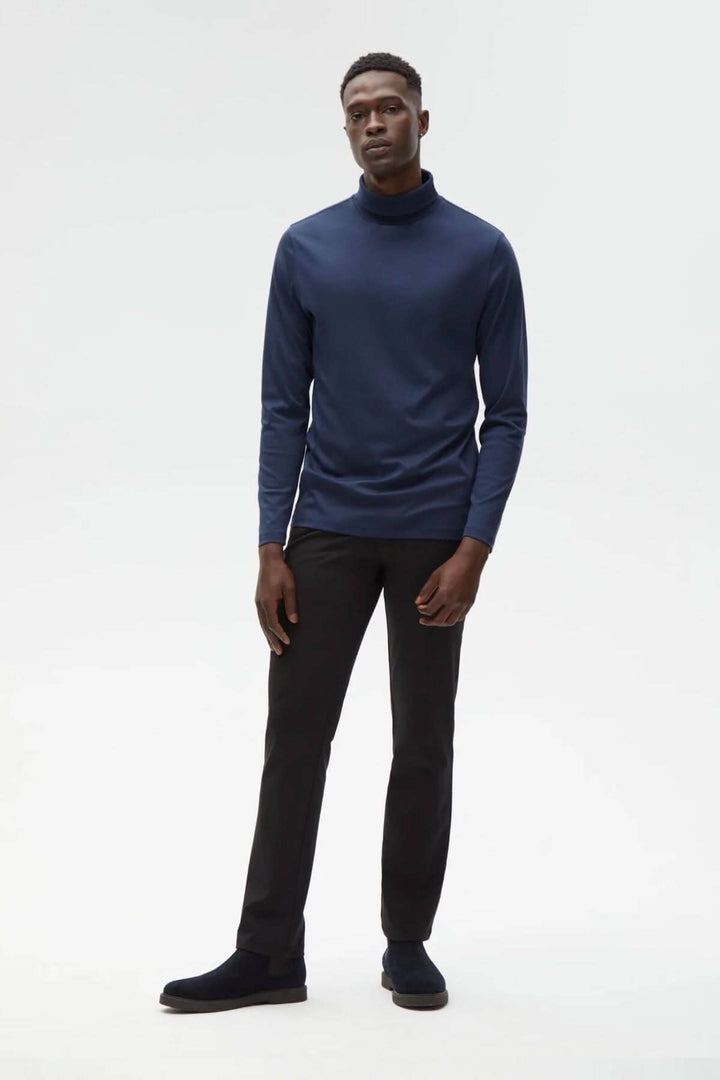 Homme portant un col roulé de coton Georgia en bleu, associé à un pantalon noir et des chaussures confortables.